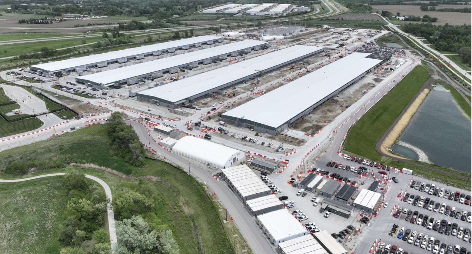 Microsoft's next data center buildings to use "zero-water" technologyA large industrial facility under construction with three long buildings wi...